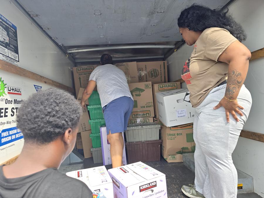 Boxes of supplies and diapers loaded into a truck for delivery.