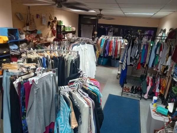 Inside the donation center, with racks of clothing across the floor.