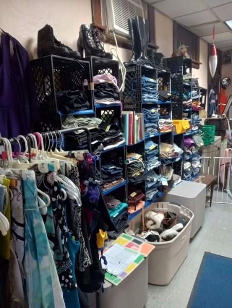 Shelves and crates of neatly sorted clothing and shoes.